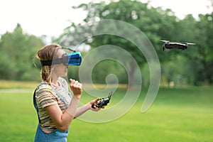 The girl controls a quadrocopter in the park with the help of a VR helmet. The concept of virtual reality. extra reality