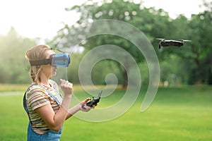 The girl controls a quadrocopter in the park with the help of a VR helmet. The concept of virtual reality. extra reality