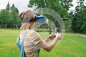 The girl controls a quadrocopter in the park with the help of a VR helmet. The concept of virtual reality. extra reality