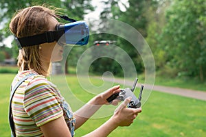 The girl controls a quadrocopter in the park with the help of a VR helmet. The concept of virtual reality. extra reality