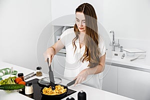 Girl cook an omelette on the pan