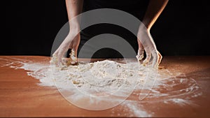 Girl cook with thin fingers kneads flour dough mixing with egg