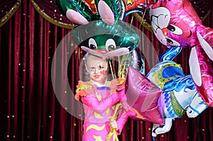 Girl in Costume Holding Bunch of Balloons on Stage