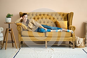Girl on couch relaxing in living room, thinking and recalling pleasant moments