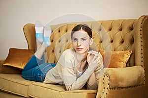 Girl on couch relaxing in living room, thinking and recalling pleasant moments photo