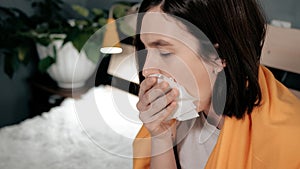 Girl coughs. Attractive young woman coughs intensively and covers her mouth with napkin. Cold, flu, sore throat, acute respiratory photo