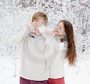 Girl covering boyfriends eyes with hands