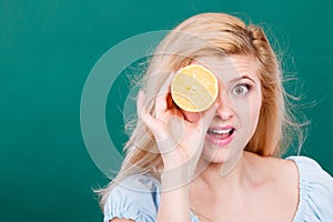 Girl covering her eye with lemon citrus fruit