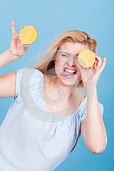 Girl covering her eyes with lemon citrus fruit