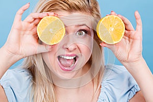 Girl covering her eyes with lemon citrus fruit