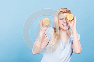 Girl covering her eyes with lemon citrus fruit