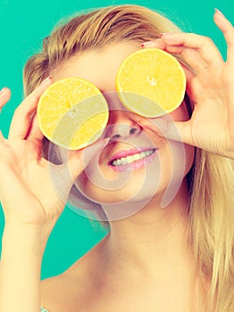 Girl covering her eyes with lemon citrus fruit