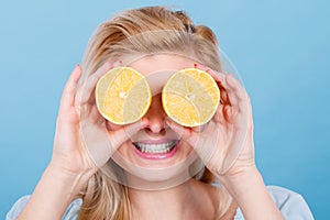 Girl covering her eyes with lemon citrus fruit