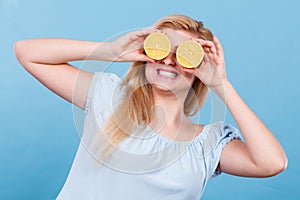 Girl covering her eyes with lemon citrus fruit