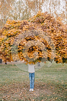 girl covers face maple autumn leaf gold