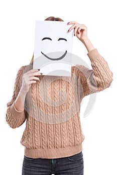 Girl covers her face with a leaf with a smiling smiley on a white background