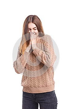 The girl covers her nose and mouth with her hands on a white background