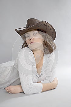 Girl in cowboy hat lies on the floor.