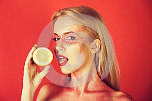 Girl with creative fashionable makeup lick lemon, vitamin