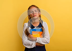 Girl cries because he has a lot of school homework. Emotional expression. Yellow background photo