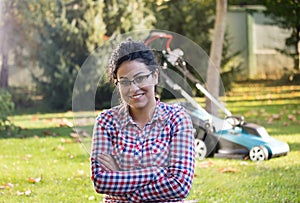 Girl with crossed arms in front of mower