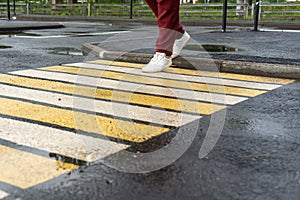 A girl crosses the road at a pedestrian crossing