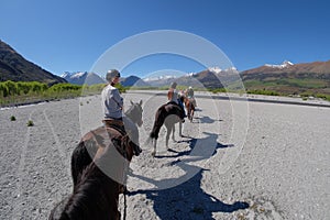 Girl crossing dry riverbed on horse in New Zealand