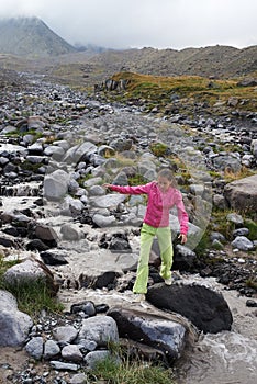 Girl is crossing mountain river