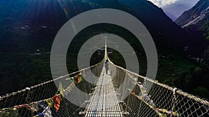 Girl crossing New Bridge in ABC trekking in Nepal