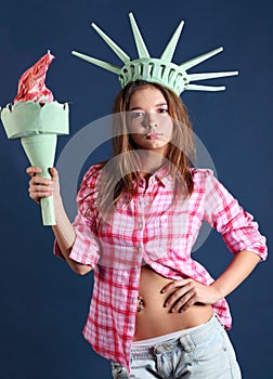 Girl with crown and torch represents statue of liberty.