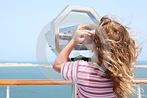 Girl on cruise liner deck and looking in binocuarl