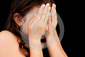 Girl crying and hiding her face