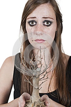 Girl crying over dead tree