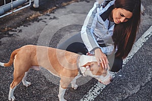 Girl cuddle her pet dog outside