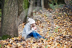 A girl with a cup of hot tea blowing on it