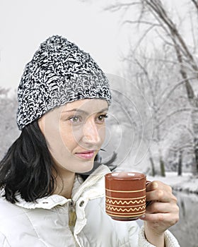 A girl with cup of tea in city park,