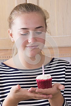 Girl with cupcake in kitchen