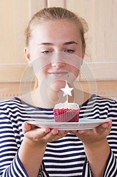 Girl with cupcake in kitchen