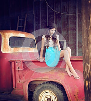 Girl with curly hair on old vintage truck