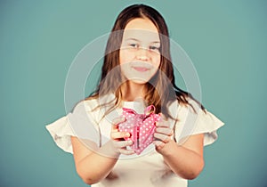 Girl cute child show heart toy. Heart symbol of love. Kid adorable girl happy face show heart blue background. Celebrate