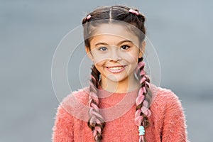 Girl with cute face smiling outdoors. Beautiful hairstyle. Fashionable hairstyle for kids. Small girl with fashionable