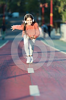 Girl cute with headphones. Little child enjoy activity. Kid walking running in park listening music. Music fills me with