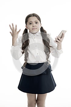 Girl cute long curly hair holds smartphone white background. Child desperate helpless face expression holds smartphone