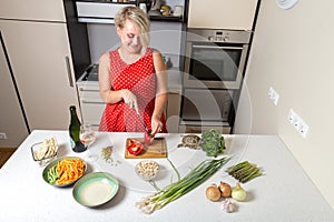 Girl cutting paprika and smiling while turtle eats