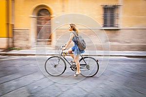 Girl cycling in the city, panning shot