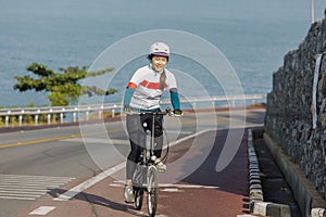 The girl cycling uphill on the road.