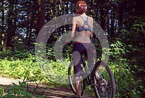 Girl cyclist on a mountain bike in a forest