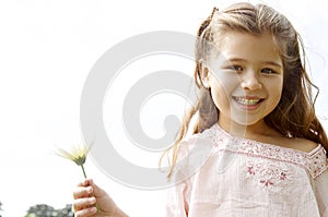 Girl with daisy in park.