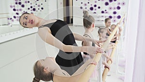 Girl dancer in ballet school learns to dance. Graceful girls in tutus dance the ballet against of a panoramic window in