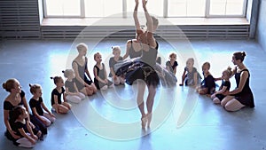 Girl dancer in ballet school learns to dance. Little ballerina in training in black dancing suit. Children`s ballet